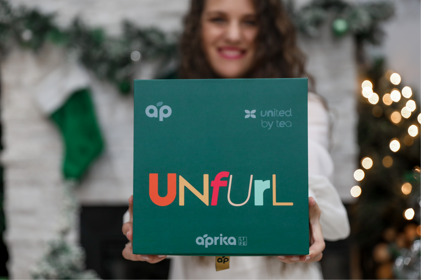 woman holding Unfurl Aprika gift box for matcha gift set