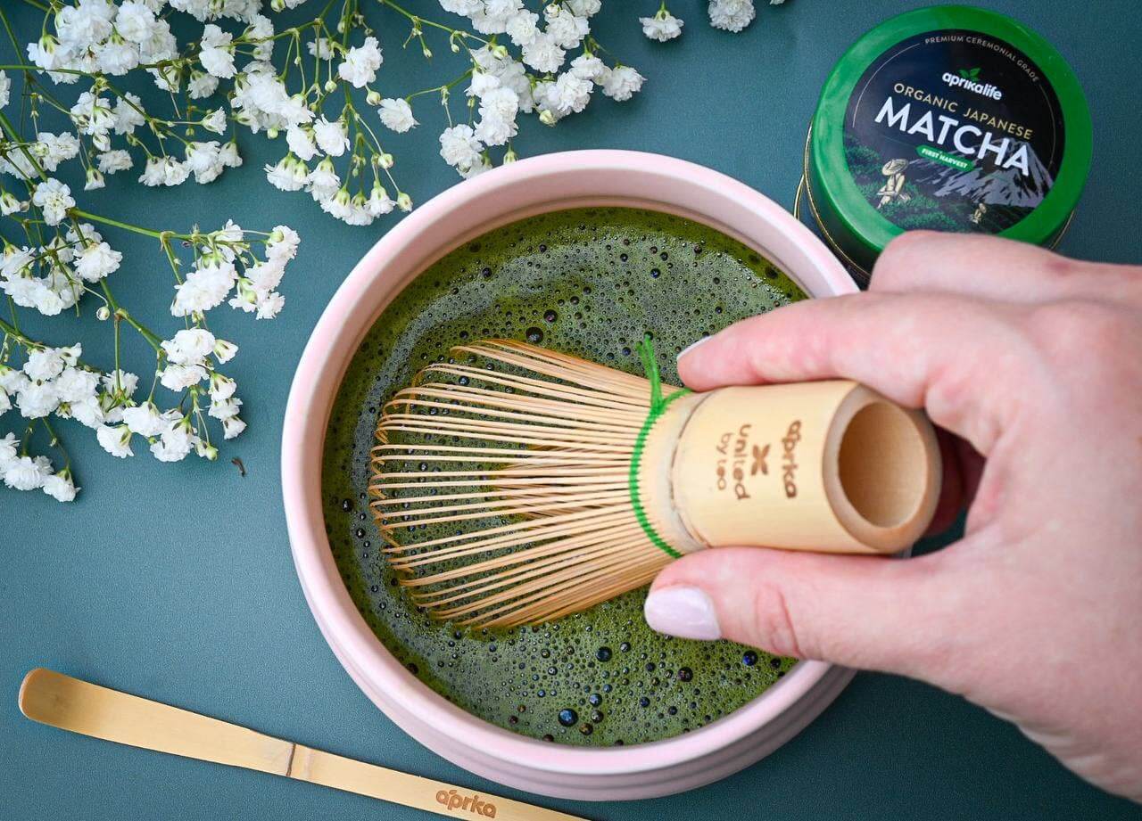 Pink matcha bowl with matcha tea, whisk chasen, matcha in tin, and matcha bamboo spoon